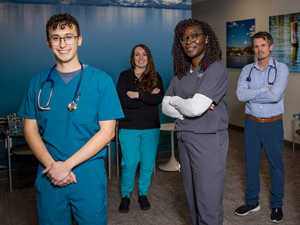 Four graduate medical students posing in a clinic waiting area