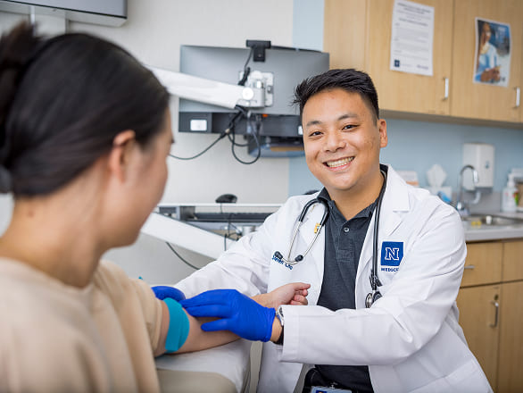 A med student works in a clinic, readying a blood draw