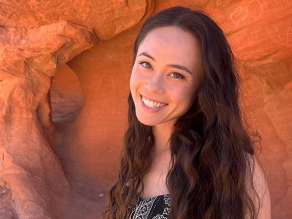 Lauryn Massic smiles with red sandstone behind her