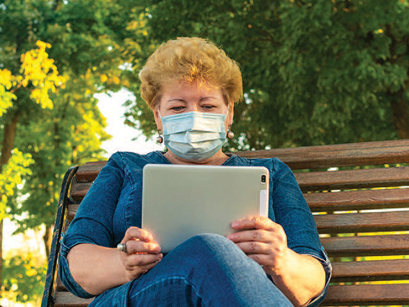 Woman reading her tablet in a park