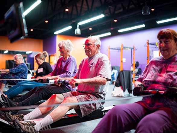 Older adults working out in a gym on rowing machines