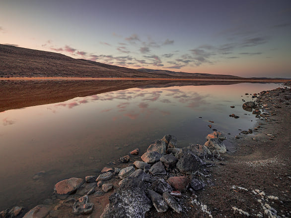 A natural Nevada landscape with clouds reflecting on water at sunset