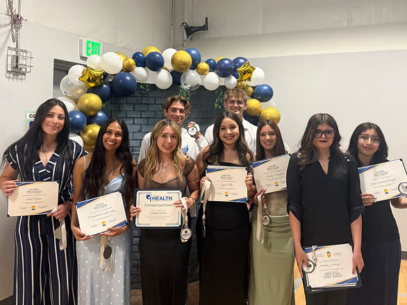 Group of ASPIRE students and staff posing with certificates at a program event.