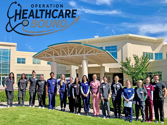 Operation Healthcare Bound participants pose outside a healthcare facility, with the program logo displayed above