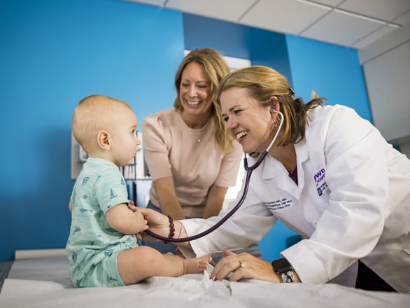 UNR Med student in blue scrubs walking down a clinic hallway
