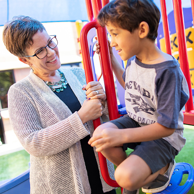 Child and speech pathologist on a playground