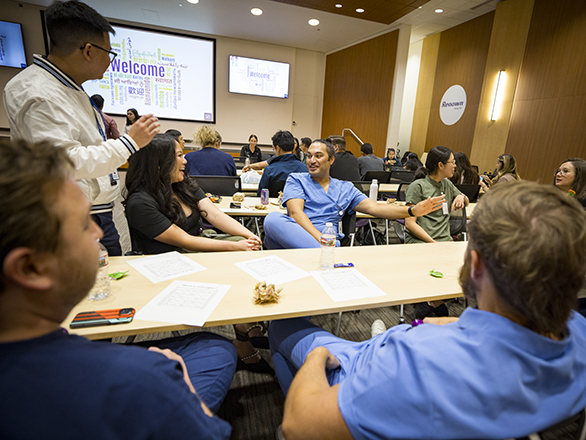 People in scrubs talking amongst themselves in a classroom.