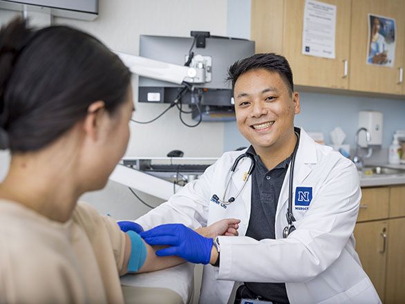 A medical student working with a patient and administering an IV.