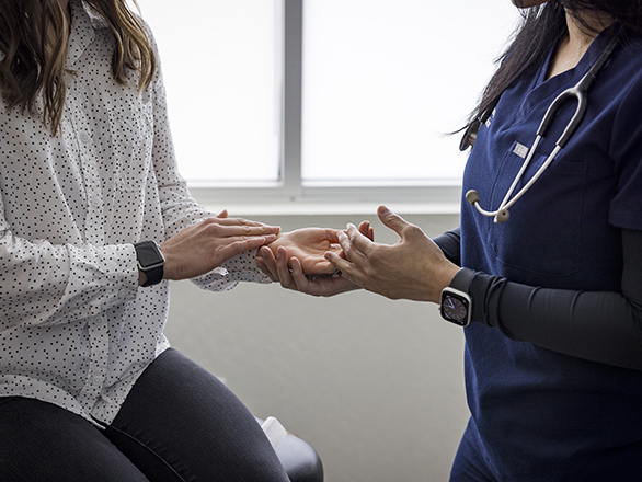 A physician checking a patient's pulse close-up of hands.