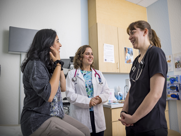 A doctor, nurse, and patient discussing in a clinical setting