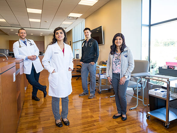 Four graduate medical students posing in a clinic waiting area