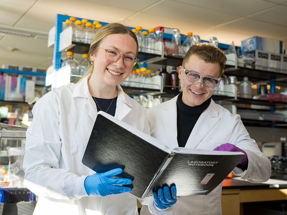 Two happy med students work in a lab