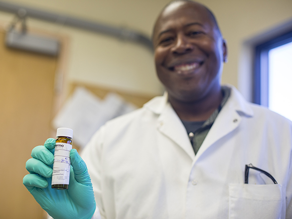 A member of the lab holding up a test tube.