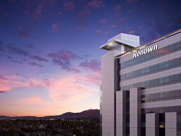 Renown Regional Tower with a sunset in the background.