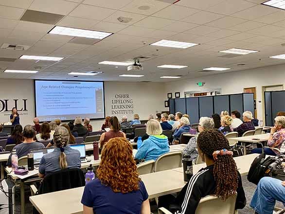 A classroom of individuals watching a presentation