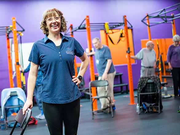 A Sanford Employee smiling while standing in front of older adults exercising