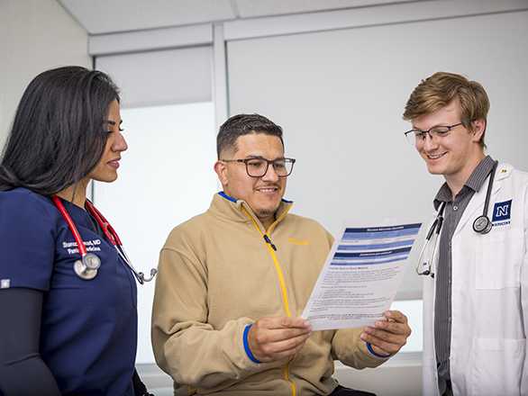 A physician and medical student discussing options with a patient in a clinic.