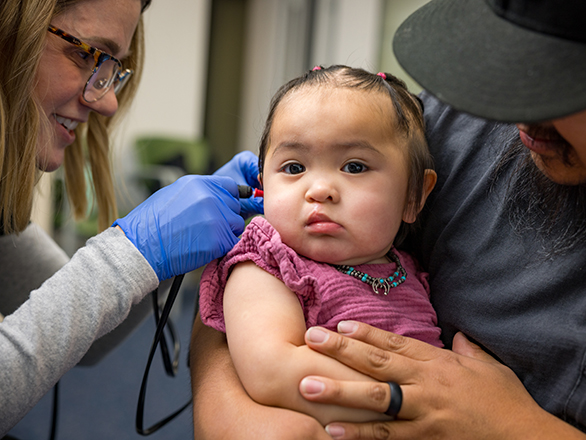 A physician looking at a child's ear.