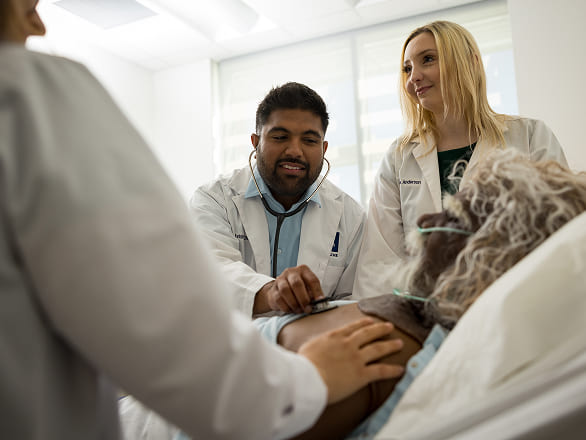 Med students work a clinical simulation with a state of the art medical dummy