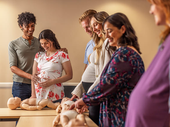 Soon-to-be parents learning how to keep simulated babies alive