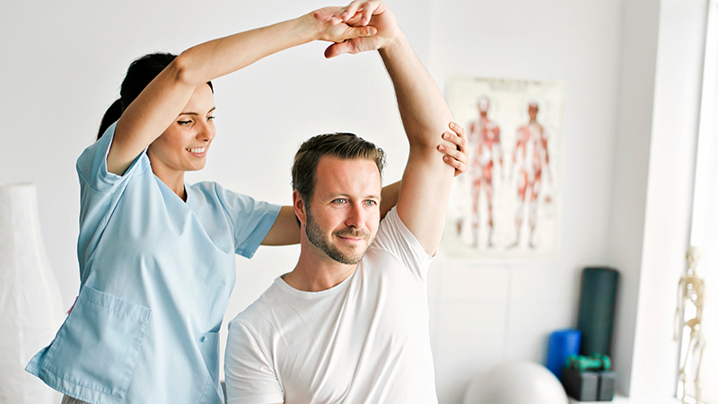 sports medicine professional with patient in clinical setting