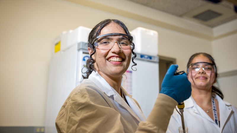 Two medical students smiling in a scientific laboratory