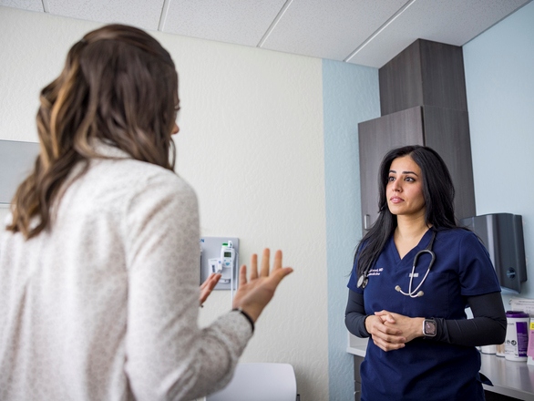 Medical student converses with a patient in a clinical setting, providing care and support.