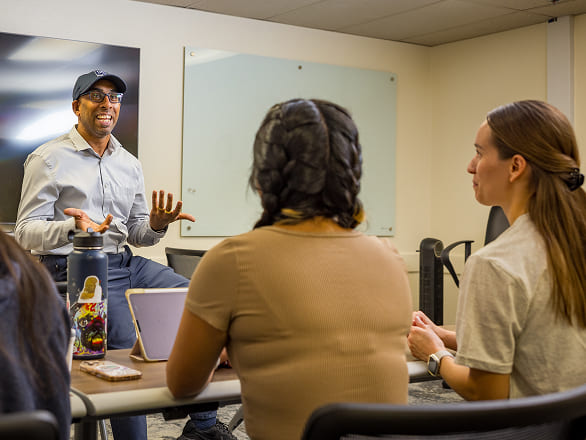 A professor talks to med students who are sitting in a classroom