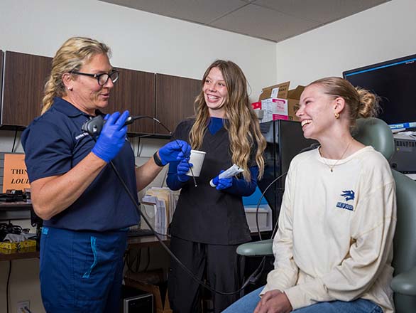 Speech-language pathology students training with a patient in a clinical setting