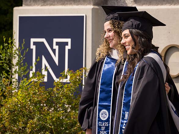 Speech-language pathology students posing for graduation wearing a cap and gown