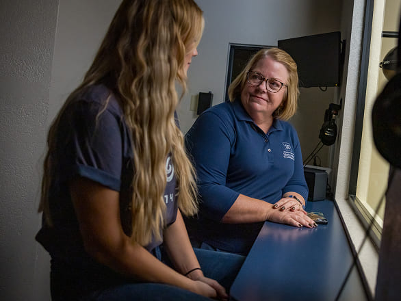 A professor talks to a med student in a practice clinical setting