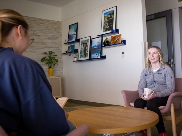 Faculty staff sitting across a student listening attentively