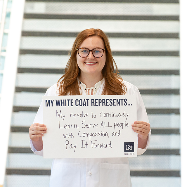 Amanda Jones holding up a sign that reads, "My resolve to coninuously learn, serve all people with compassion, and pay it forward."