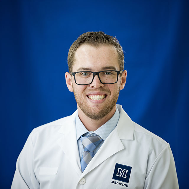 Carson Spade in a white coat headshot.