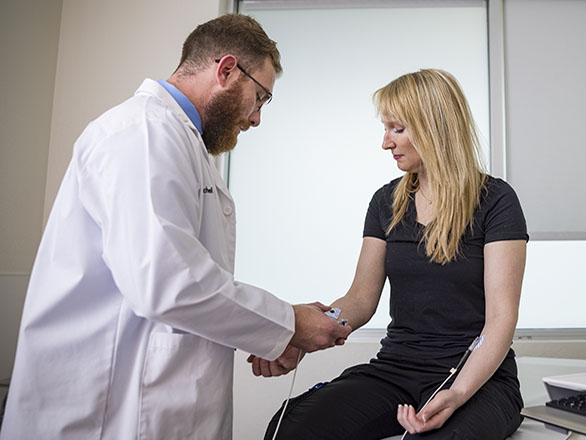 A physician looking at a patient's arm.