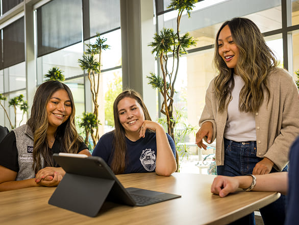 Students gather around a tablet during a collaborative discussion