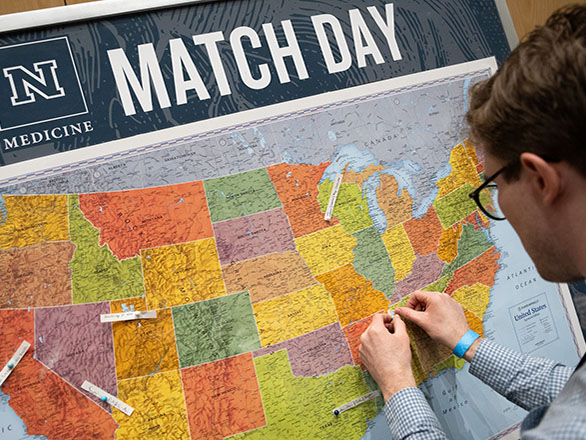 A student pinning a Match Day residency location on a map.