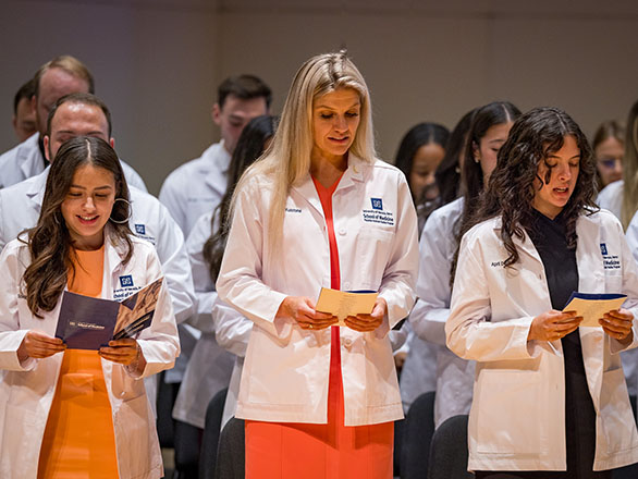 PA students reciting the Physician's Oath on stage.